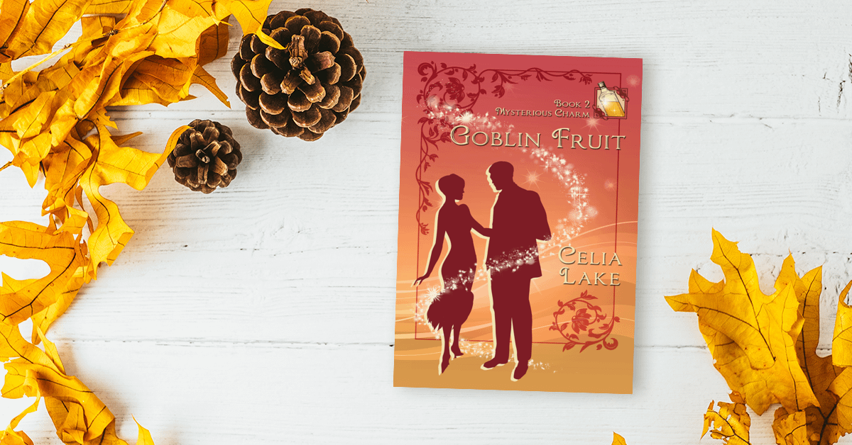 Copy of Goblin Fruit lying on a white wood desk, surrounded by golden yellow leaves and pinecorns that highlight the yellow in the cover.